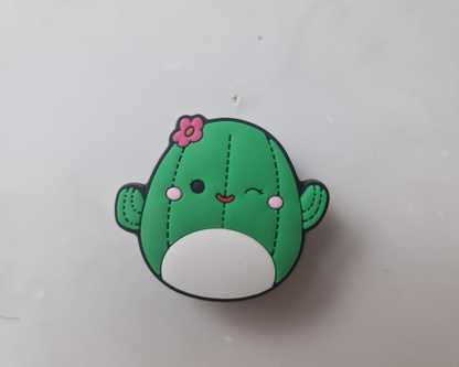 a green cactus with a pink flower on its head