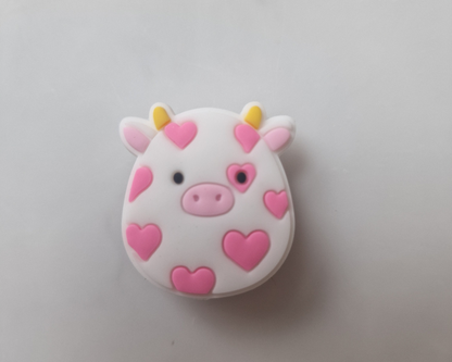 a white cow with pink hearts on it's face