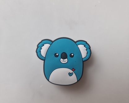 a blue and white koala brooch sitting on top of a table